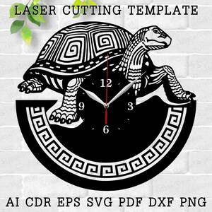 May include: Black and white laser cut clock design featuring a turtle with a Greek key border. The clock face has Roman numeral markings.