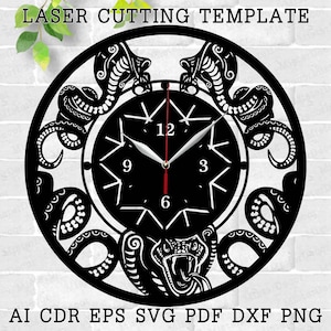 May include: Black laser-cut wall clock featuring a cobra design. The clock face has a starburst pattern with the numbers 12, 3, 6, and 9. The clock hands are black and the second hand is red. The text "LASER CUTTING TEMPLATE" is at the top.