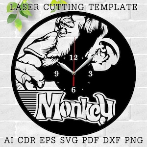 May include: Black and white laser cut clock template featuring a monkey design with the word "Monkey" below. The clock face has Roman numeral markings for the hours.