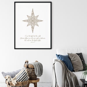 May include: A printable wall art design featuring a stylized star with a floral pattern in brown. The text "I am the light of the world. Whoever follows me will never walk in darkness, but will have the light of life. John 8:12" is printed below the star.