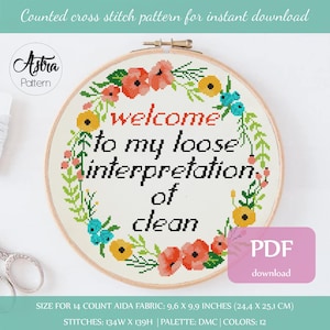 Könnte beinhalten: PDF-Download für ein Kreuzstichmuster mit einem Blumenkranz und dem Text "Welcome to my loose interpretation of clean". Das Muster ist für Aida-Stoff mit 14 Fäden pro 10 cm und misst 9,6 x 9,9 Zoll (24,4 x 25,1 cm).