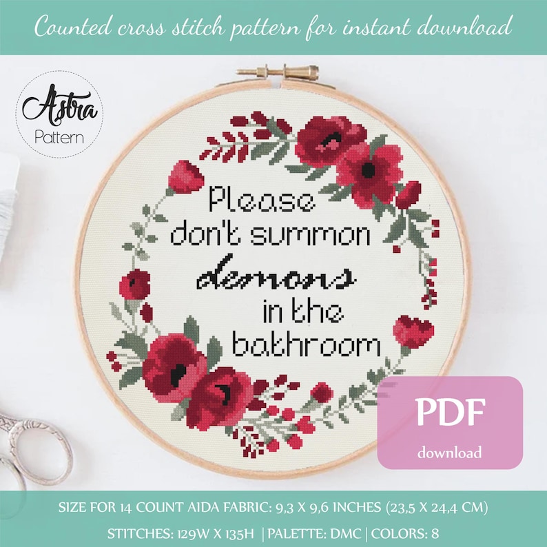 Op de afbeelding: Een kruissteekpatroon met een bloemenkrans met rode bloemen en groene bladeren rond de tekst "Please don't summon demons in the bathroom". Het patroon is voor 14-count Aida-stof en meet 9,3 x 9,6 inch (23,5 x 24,4 cm).