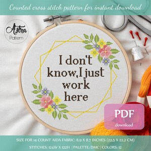 May include: Cross stitch pattern for a hoop with a floral design and the text "I don't know, I just work here". The pattern is for 14 count Aida fabric and measures 8.9 x 8.7 inches (22.5 x 22.2 cm).