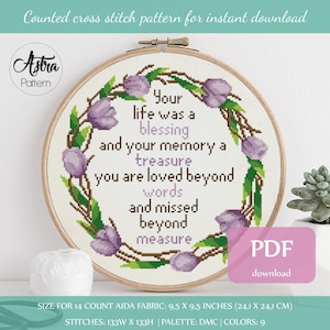 Puede incluir: Un patrón de punto de cruz con una corona de flores moradas con el texto "Your life was a blessing and your memory a treasure you are loved beyond words and missed beyond measure". El patrón es para una pieza de tela Aida de 14 puntos de 9,5 x 9,5 pulgadas (24,1 x 24,1 cm) y utiliza 9 colores DMC.