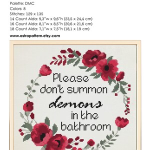 Op de afbeelding: Borduurpatroon met een bloemenkrans met rode bloemen en groene bladeren. De tekst "Please don't summon demons in the bathroom" staat in het midden van de krans.