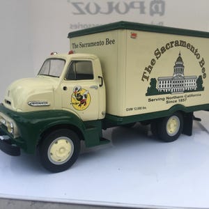 Puede incluir: Camión modelo vintage crema, verde y negro, con el logo "The Sacramento Bee". El camión presenta un gráfico de abeja y el Capitolio de California. Un artículo coleccionable con detalles precisos.