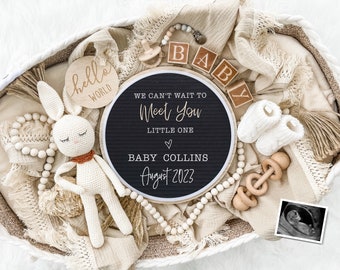 May include: A white wicker basket filled with baby items, including a crocheted bunny, wooden beads, a sign that reads "We can't wait to meet you little one, Baby Collins, August 2023", and a small ultrasound image.