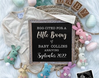 Peut inclure: Un tableau noir avec l'inscription "Egg-cited for a Little Bunny" et "Baby Collins Arriving September 2022". Le tableau est entouré de décorations de lapin en feutre de couleur pastel et d'un body de bébé. Il y a aussi une image d'échographie en noir et blanc.