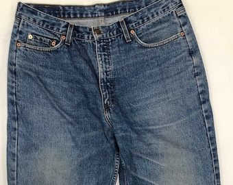 May include: A pair of blue denim jeans with a straight leg fit. The jeans have a classic five-pocket design and a button fly.