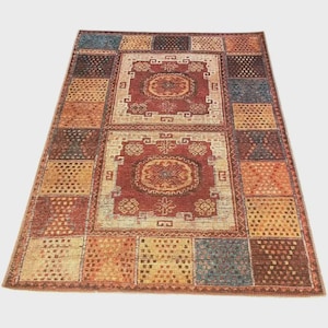 Op de afbeelding: Een rechthoekig vloerkleed met een patchwork-ontwerp. Het vloerkleed heeft een centraal medaillon in tinten rood en beige, omgeven door een rand van vierkanten met patronen in verschillende kleuren, waaronder oranje, blauw en bruin.