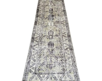 May include: A distressed-look runner rug with a geometric pattern in shades of gray, black, and cream. The rug has a rectangular shape and a faded, vintage appearance, suitable for a hallway or entryway.