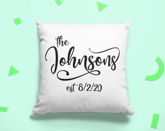 Puede incluir: Almohada blanca con texto negro que dice "the Johnsons est 8/2/20" sobre un fondo verde claro con formas geométricas verdes.
