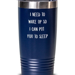 May include: A navy blue stainless steel tumbler with a white lid and a white inscription that reads "I need to wake up so I can put you to sleep."