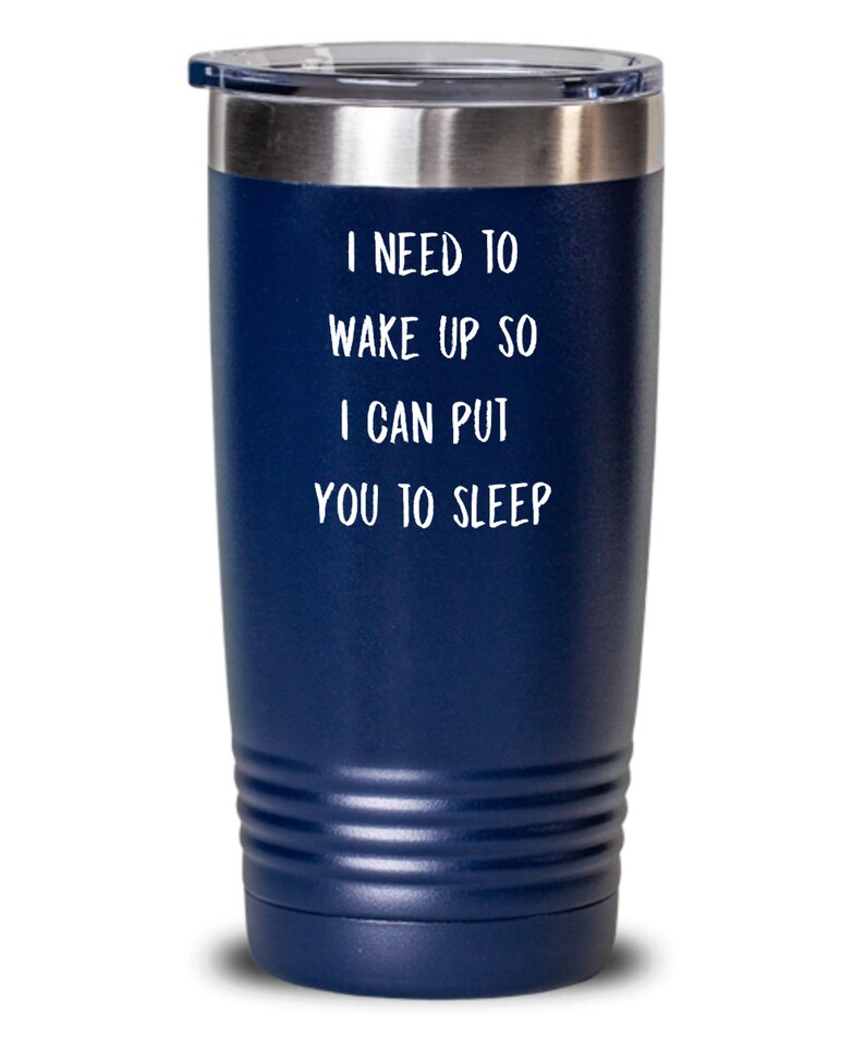 May include: A navy blue stainless steel tumbler with a white lid and a white inscription that reads "I need to wake up so I can put you to sleep."