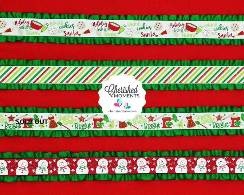 May include: A red background with various ribbons. Some ribbons have green ruffles. One ribbon says "Holiday baking cookies for Santa". Other ribbons feature stripes, snowmen, and baking-themed graphics. The text "SOLD OUT" is visible.