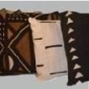 May include: Three decorative throw pillows with geometric patterns. The pillows are made of a natural fabric with a white background and brown accents. The patterns include a diamond pattern, a chevron pattern, and a series of small arrows.