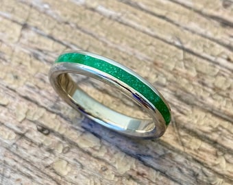 Könnte beinhalten: Ein silberner Ring mit einem dünnen grünen Band aus eingelegtem Stein.