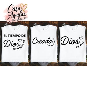 May include: Three white t-shirts featuring black text and heart graphics. The first shirt reads EL TIEMPO DE Dios ES PERFECTO. The second shirt reads Creada CON PROPOSITO. The third shirt reads Dios ES FIEL. Each shirt has a crew neckline and short sleeves.
