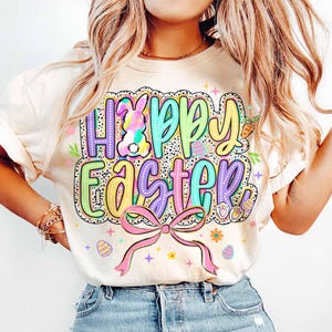 May include: A white t-shirt with a colorful graphic that says "Happy Easter" with a bunny, eggs, and a bow.