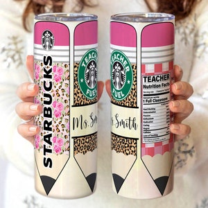Op de afbeelding: Een roestvrijstalen tumbler met een roze, wit en zwart ontwerp. De tumbler heeft een potloodontwerp met de woorden "Starbucks" en "Teacher Fuel" erop. De tumbler heeft ook een voedingswaarde-etiket met de tekst "Teacher Nutrition Facts".
