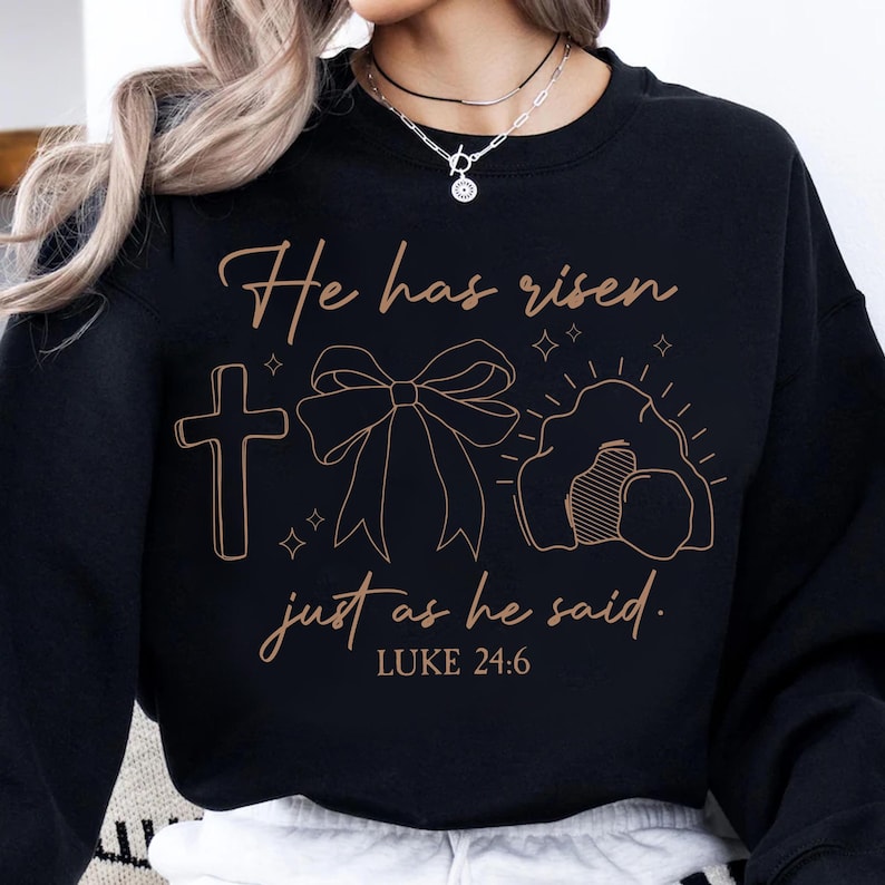 May include: Black sweatshirt with a brown graphic design that says "He has risen just as he said. Luke 24:6". The graphic includes a cross, a bow, and a tomb.