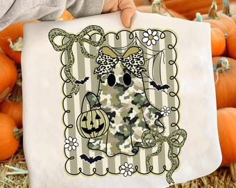 May include: A white Halloween-themed sweatshirt featuring a ghost with a camouflage pattern, holding a jack-o'-lantern. The design includes bows, bats, and daisies, all framed by a striped border. The ghost has black eyes and a leopard print bow.