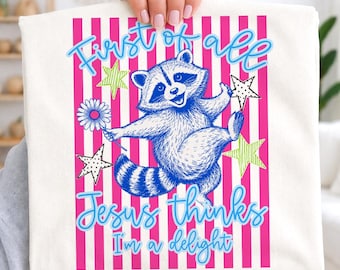 May include: A white t-shirt with a blue and white illustration of a raccoon holding a flower and a star. The shirt has pink vertical stripes and the text "First of all Jesus thinks I'm a delight" in blue and light blue.