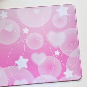 May include: Pink mouse pad with a white design of stars, hearts, and circles.