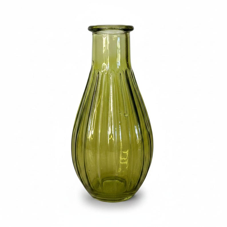 May include: A translucent olive green glass vase with a bulbous, teardrop-shaped body and a narrow neck. The exterior surface features vertical ribbed detailing that runs from the base up to the rim, creating a textured, fluted appearance.