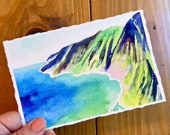 以下が含まれることがあります： 緑と青の風景を描いた水彩画。山脈と水域が描かれている。絵は、ゆったりとした印象派のスタイルで描かれている。