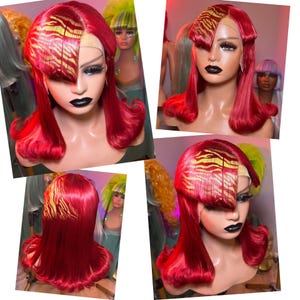 May include: A vibrant red wig featuring a side-swept bang with a gold tiger-stripe pattern. The hair is shoulder-length with curled ends and a lace front construction. The wig is displayed on a mannequin head with dark makeup and black lipstick.