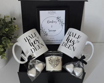 May include: A black gift box with a white mug that says "HALF her DEEN" and another white mug that says "HALF his DEEN". The box also contains a white candle with Arabic calligraphy and two silver heart-shaped chocolates.