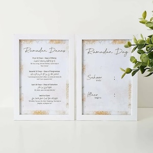 Puede incluir: Dos impresiones enmarcadas blancas con un fondo blanco desgastado y detalles dorados. La impresión de la izquierda tiene el título "Ramadan Duaas" e incluye texto árabe y traducciones al inglés. La impresión de la derecha tiene el título "Ramadan Day" e incluye las palabras "Suhoor ends" y "Iftar begins".
