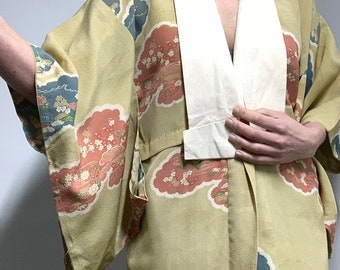 Könnte beinhalten: Ein hellgrüner Kimono mit weißem Kragen und einem Blumenmuster. Der Kimono hat ein traditionelles japanisches Design mit Wolken und Blumen.
