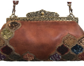 May include: A brown leather handbag with a decorative metal clasp and strap. The bag features ornate beaded and sequined embellishments in shades of green, gold, red, and purple. The bag is approximately 30 cm wide.
