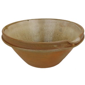 May include: A handmade, terracotta-colored ceramic bowl with a wide rim and a spout. The interior has a lighter, off-white hue with visible texture. The bowl's exterior is a warm, earthy tone, suggesting a rustic or artisanal aesthetic.