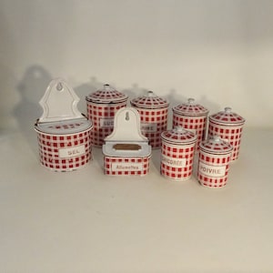 Puede incluir: Conjunto de ocho botes de esmalte vintage con un patrón de cuadros rojos y blancos. Los botes están etiquetados con "Sel", "Suc", "Rine", "Chicoree", "Poivre" y "Allumettes".