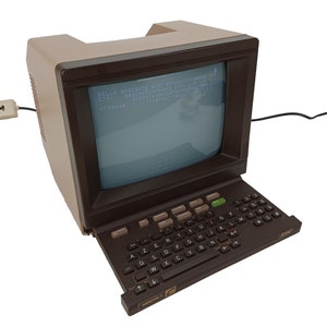 May include: A brown vintage computer with a built-in monitor and a keyboard. The monitor displays text in French. The text on the screen reads "BELLE BROCANTE AVEC BROCANTENFRANCE SROCANTENFRANCE ETSY COM AZERTVUSOPOSOFCH ETSY 570980411N".