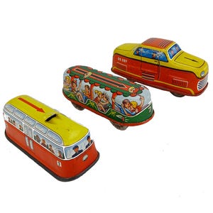 May include: Three vintage toy vehicles: a red and yellow bus, a green and silver bus, and a red and yellow car. The buses have illustrations of people. The car has the number "GE 297" on the side.