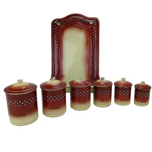 Puede incluir: Un juego de botes de cocina vintage con un marco decorativo a juego. Los botes son rojos con lunares blancos y bases color crema. El marco y las tapas son rojas. Los botes están etiquetados "SUCRE", "FARINE", "CAFE", "PATES", "CHICORE" y "POIVRE".