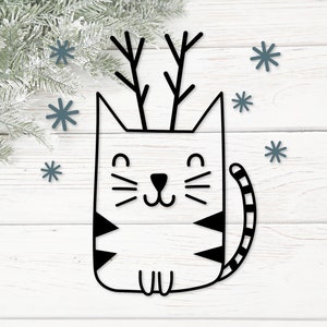 May include: Black and white line art illustration of a cat with reindeer antlers. The cat is sitting with its legs tucked under its body. There are snowflakes in the background.