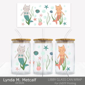 Puede incluir: Vasos de vidrio transparente con forma de lata con tapas de bambú y pajitas. Cada vaso presenta un diseño de gato sirena con estrellas de mar, algas y burbujas. El diseño se repite en un fondo rectangular. El texto de la imagen dice "Lynda M. Metcalf DESIGN" y "LIBBY GLASS CAN WRAP For UVDTF Printing".