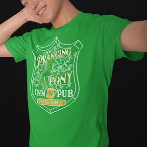 May include: Green t-shirt with a white graphic of a crest featuring a prancing pony and the text "The Prancing Pony Inn & Pub, Village of Bree".