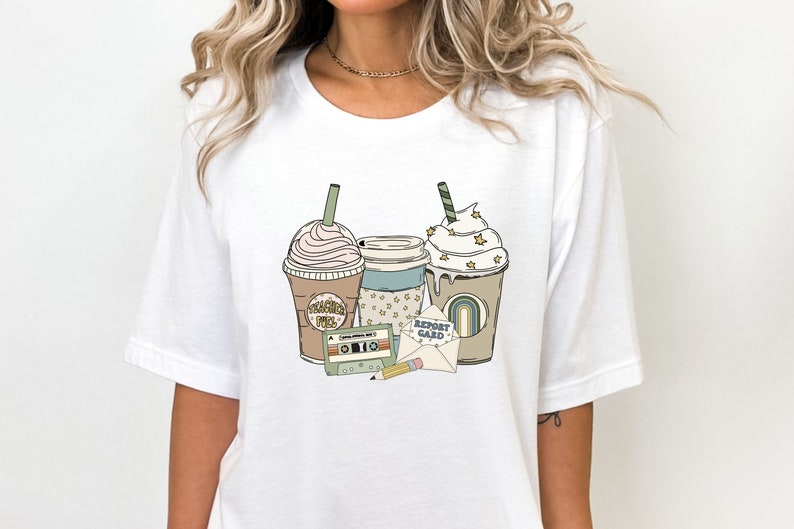 May include: White t-shirt featuring a retro-style graphic with three coffee drinks, a cassette tape, a pencil, and an envelope with the words "Report Card". The coffee cups have whipped cream and star accents.
