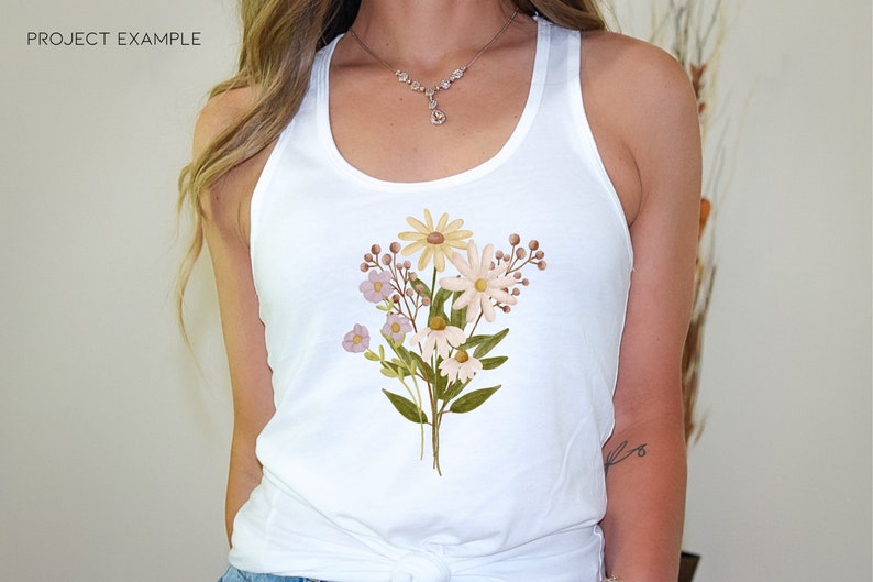 May include: A white tank top with a floral design featuring yellow, pink, and brown flowers. The flowers are arranged in a bouquet shape and are centered on the front of the tank top.
