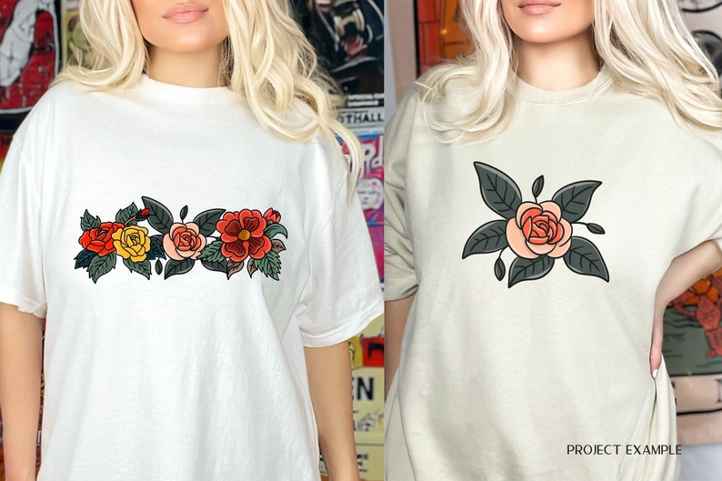 May include: Two white t-shirts with floral designs. The first shirt has a row of three roses with green leaves. The second shirt has a single rose with green leaves.