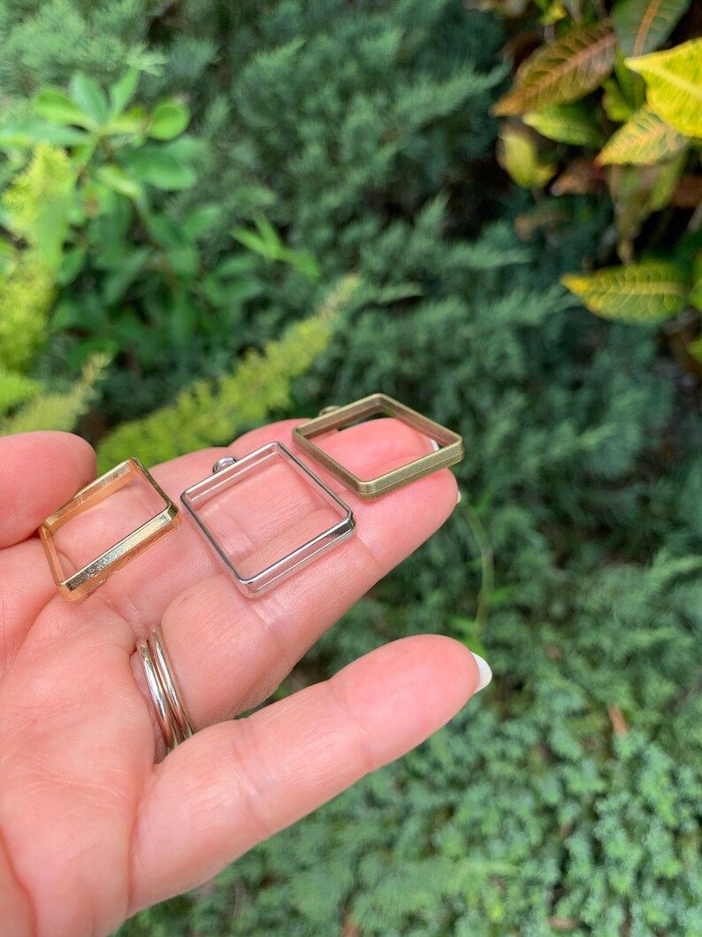 K&ouml;nnte beinhalten: Drei quadratische Metallrahmen in verschiedenen Gr&ouml;&szlig;en. Die Rahmen sind in Gold, Silber und Messing.