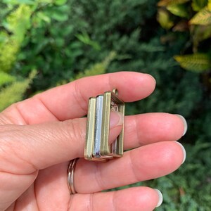 K&ouml;nnte beinhalten: Drei quadratische Metallrahmen, einer silber und zwei gold, &uuml;bereinander gestapelt. Die Rahmen sind daf&uuml;r ausgelegt, ein kleines Bild oder einen anderen Dekorationsgegenstand zu halten.