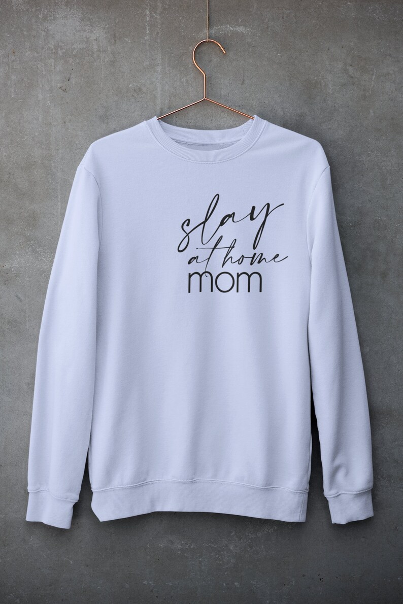 May include: White sweatshirt with black text that reads "slay at home mom".