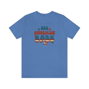 May include: A light blue t-shirt with the text "All American Babe" in red, white and blue with a star design.